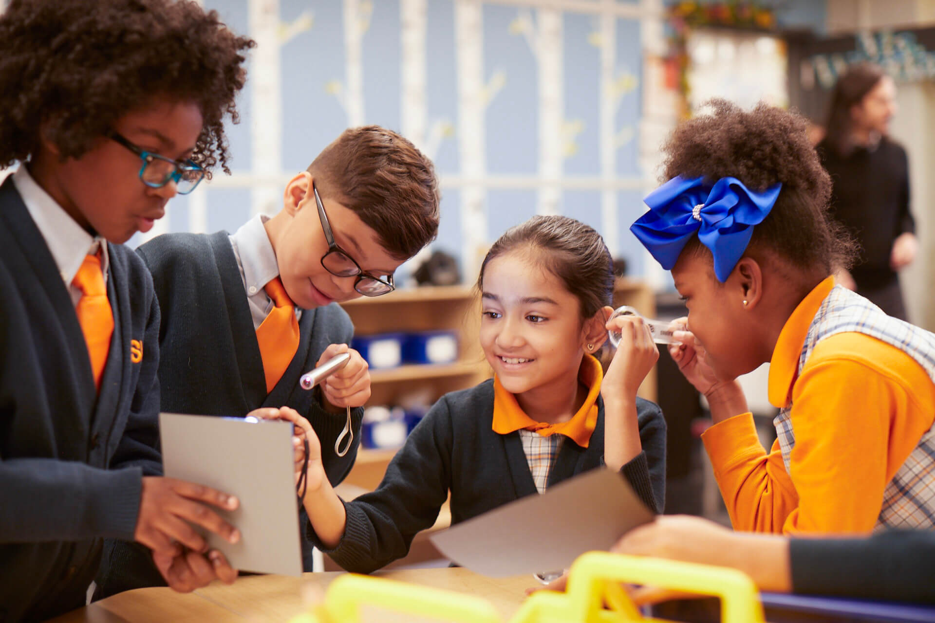 People talking at an event, wearing orange lanyards.