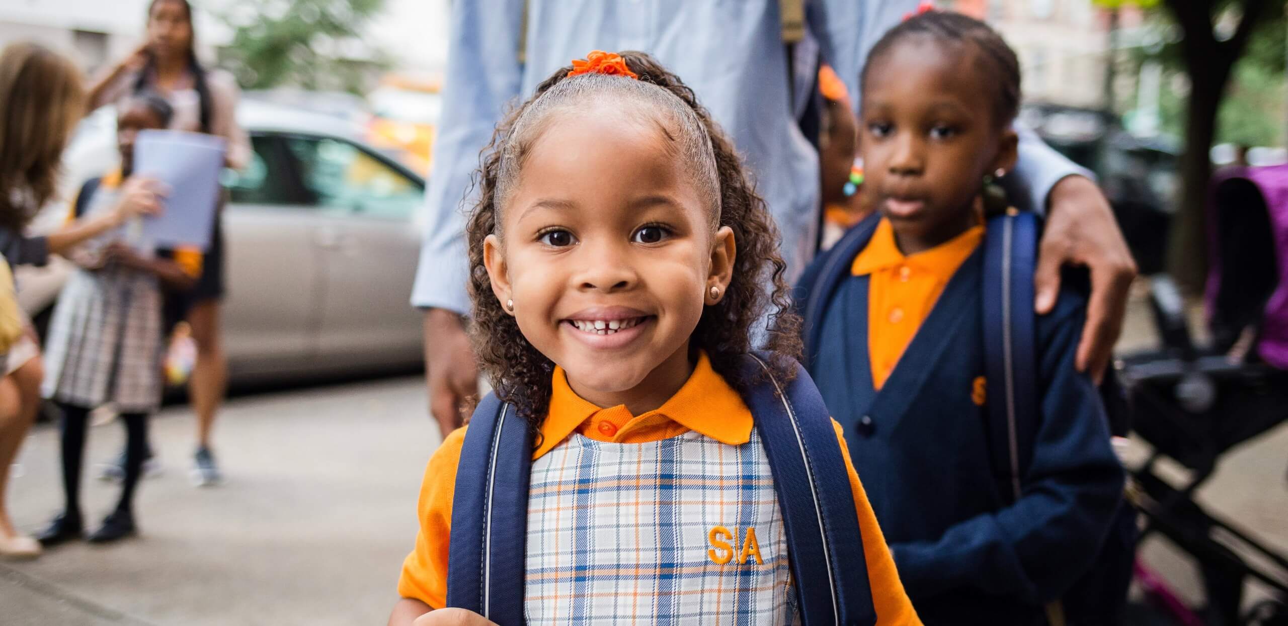 Student smiling wearing a plaid charter school uniform