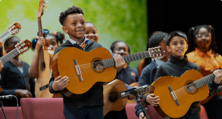 Students playing guitars in a music class