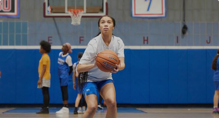 Student getting ready to shoot a basketball on an indoor court