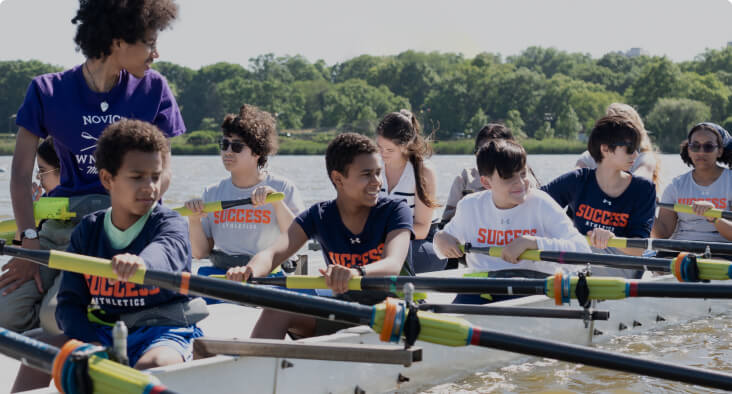 Students participating in a rowing activity on the water