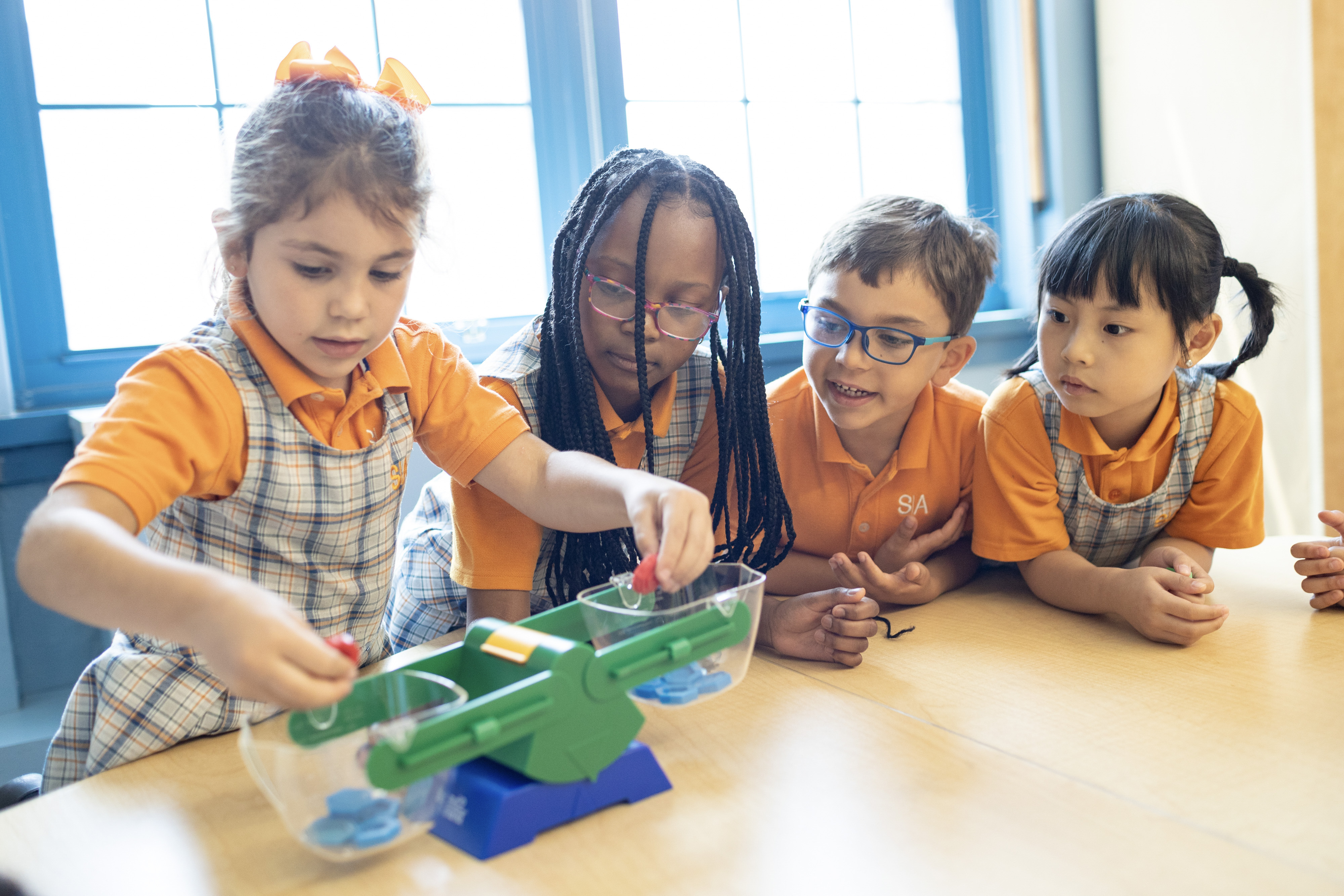 A young girl balancing on a colorful play apparatus during a kindergarten education activity.